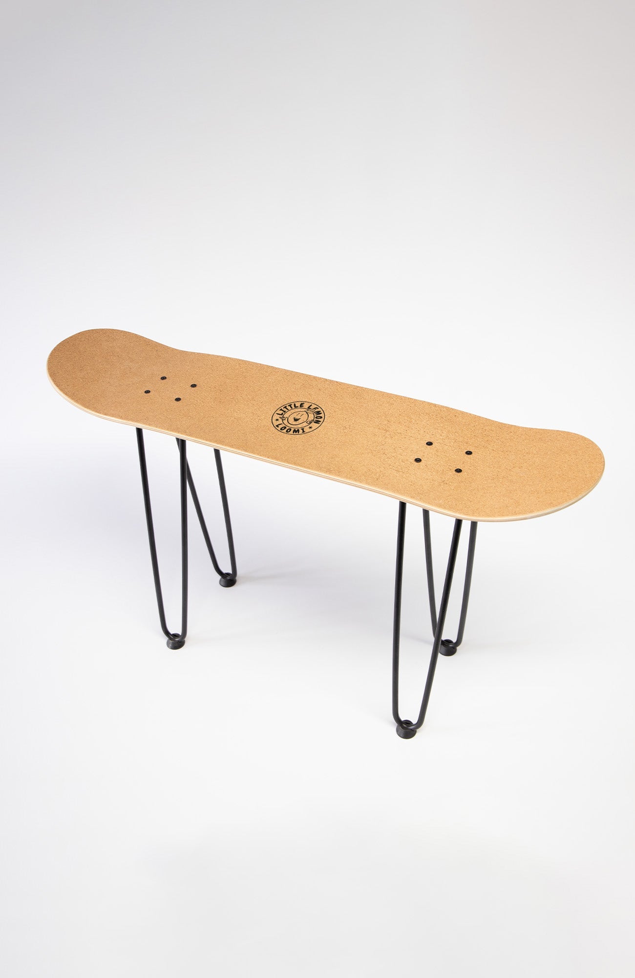 eine bank aus einem skateboard deck mit schwarzem Metall Gestell. die Oberseite ist mit kork bezogen.