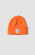 orangene beanie mit weißem Aufnäher auf dem umschlag