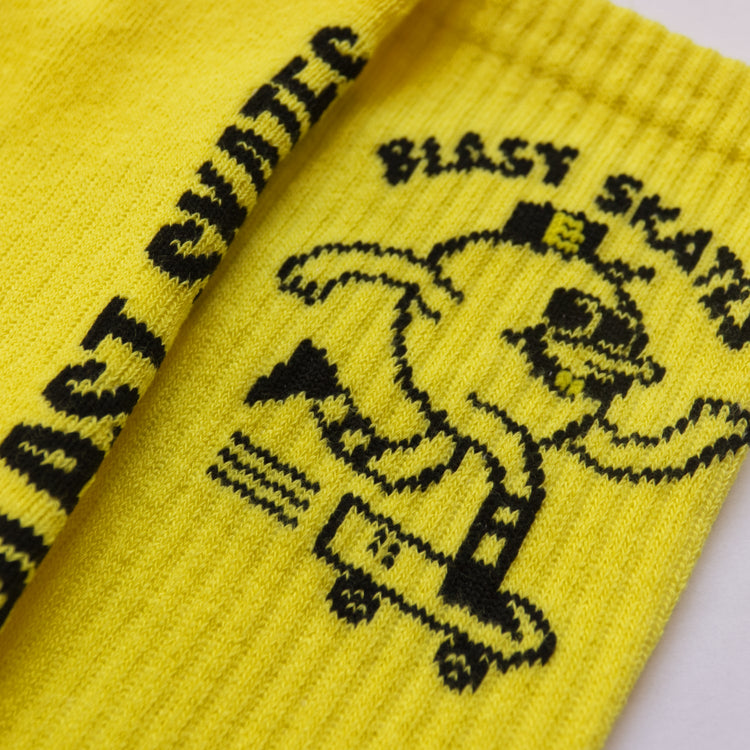 Nahaufnahme von einem schwarzen Logo, dass in eine gelbe Socke eingestrickt wurde