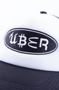 Detail Foto von einem stick auf einer trucker cap. Der Schriftzug "ÜBER" ist zu sehen und die Buchstaben bestehen aus Markenlogos wie bitcoin oder mcdonalds