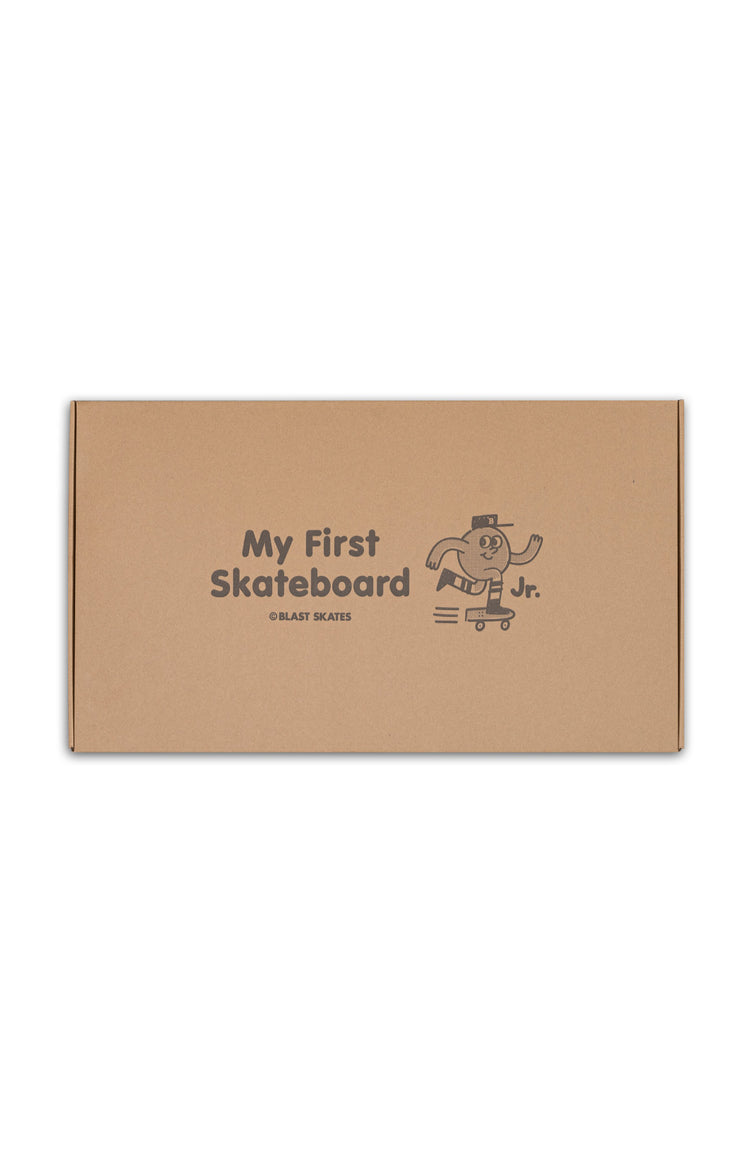 Karton mit "My first Skateboard" Aufdruck und dem "Blast Skates Jr"-Maskottchen. der Karton liegt in der Mitte des Bildes, auf einem weißem hintergrund.
